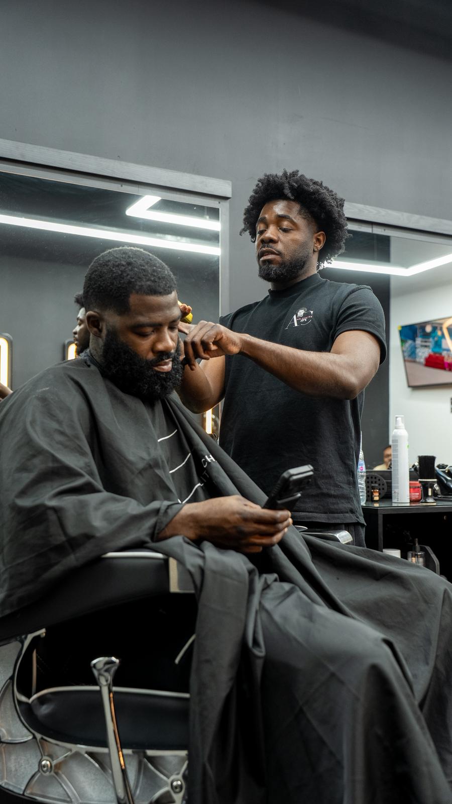 Elite Chair barber shaping a client haircut in East London