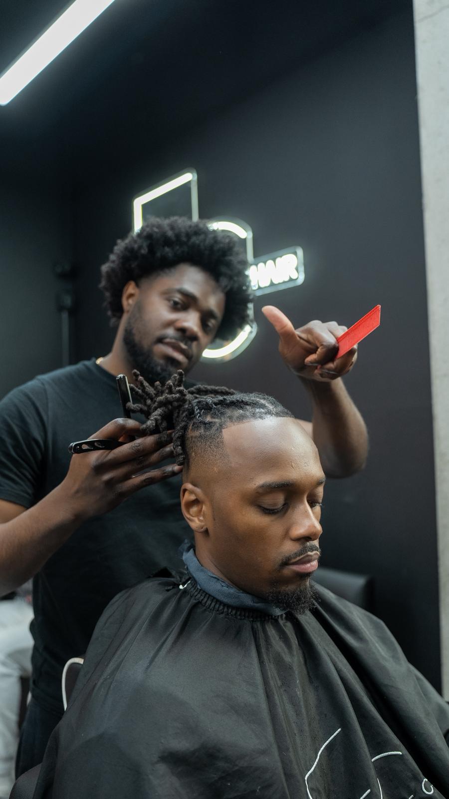 Elite Chair barber working on twists and locks