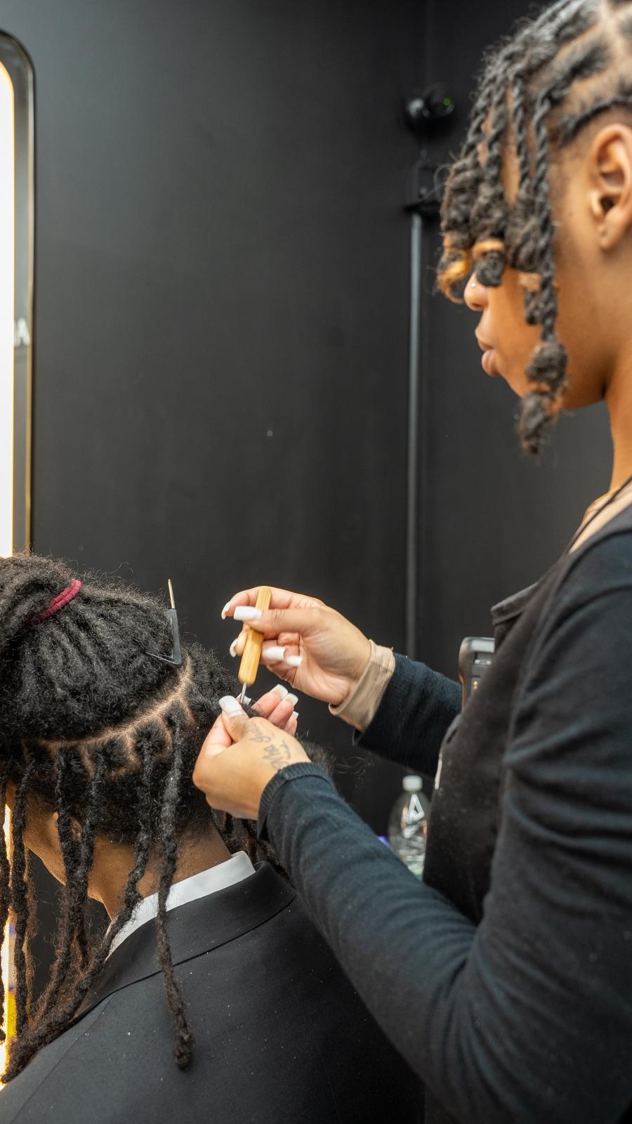 Elite Chair hairdresser working on locks with studio branding
